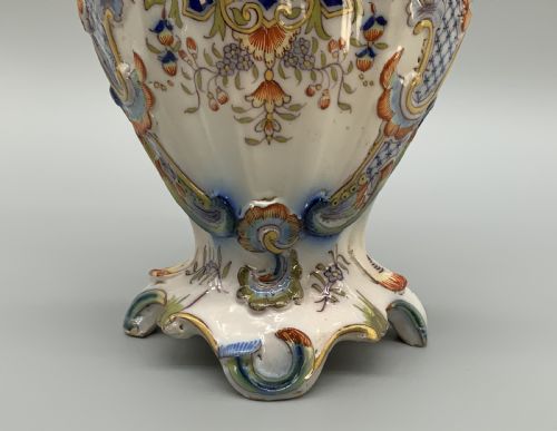 fig 9. A pair of ornate French faience lidded vases decorated with hand-painted polychrome florals, Rococo scrollwork moulding, and sculptural parrot finials.