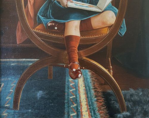 fig 7. An oil portrait on canvas depicting a young child in a blue dress seated in a wooden chair, enclosed within an ornate giltwood frame.