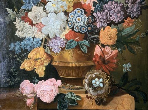fig 5. A gilt-framed oil painting featuring a dense bouquet of colourful flowers in a classical urn alongside a birds nest with eggs.
