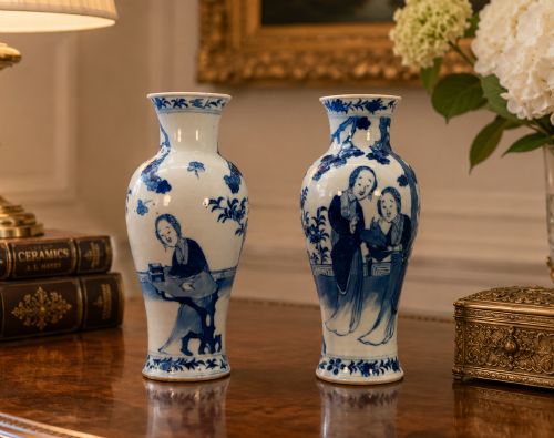 fig 1. A pair of flared Chinese blue and white porcelain vases hand painted with figural court ladies amidst floral motifs.
