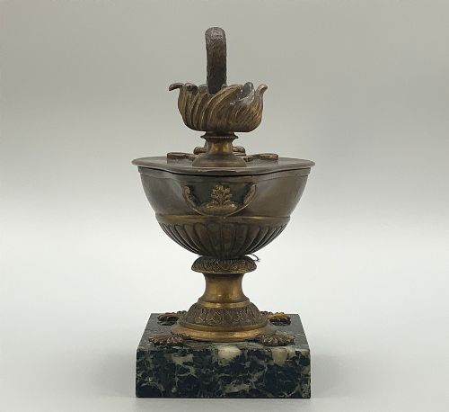 fig 8. A nineteenth-century Grand Tour patinated bronze oil lamp featuring a serpent handle and gadrooned body, mounted on a square green marble base.