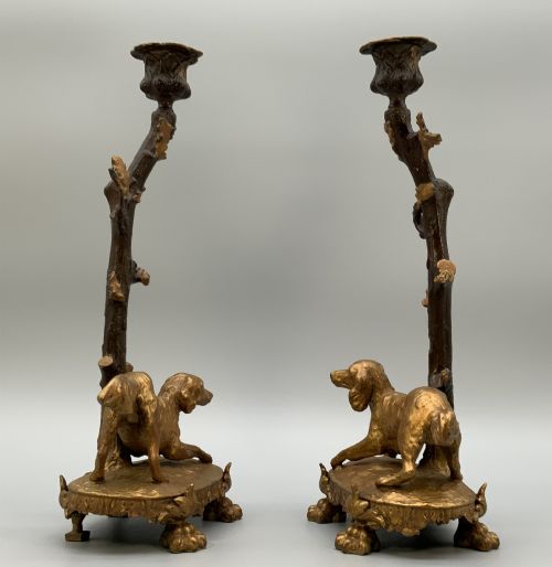 fig 5. A pair of 19th-century gilded and patinated bronze candlesticks featuring detailed figures of hunting dogs at the base beneath tree-branch shafts.