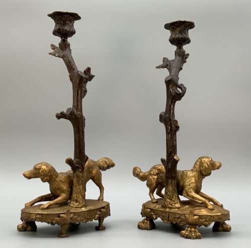 fig 9. A pair of 19th-century gilded and patinated bronze candlesticks featuring detailed figures of hunting dogs at the base beneath tree-branch shafts.