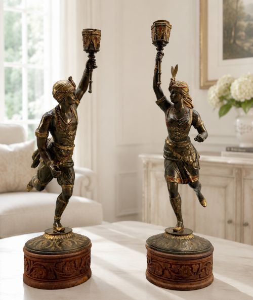 fig 1. A pair of 19th-century polychrome spelter figural candlesticks depicting male and female torchbearer figures raised on carved wooden bases.