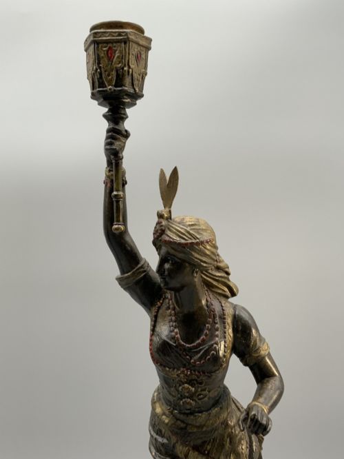 fig 3. A pair of 19th-century polychrome spelter figural candlesticks depicting male and female torchbearer figures raised on carved wooden bases.