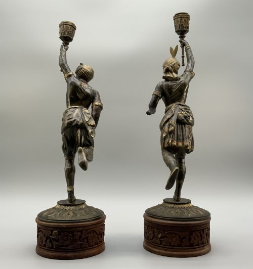 fig 11. A pair of 19th-century polychrome spelter figural candlesticks depicting male and female torchbearer figures raised on carved wooden bases.