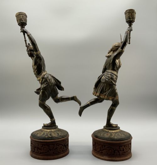 fig 12. A pair of 19th-century polychrome spelter figural candlesticks depicting male and female torchbearer figures raised on carved wooden bases.