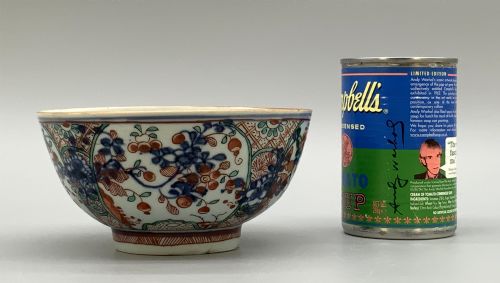 fig 2. An antique deep circular porcelain bowl featuring hand-painted Chinese Imari floral foliage and diaper pattern borders in blue, red, and green.