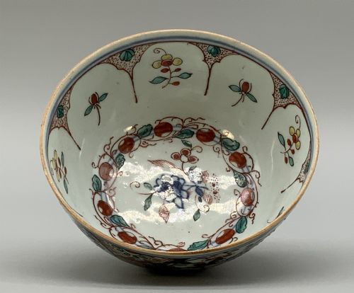 fig 6. An antique deep circular porcelain bowl featuring hand-painted Chinese Imari floral foliage and diaper pattern borders in blue, red, and green.