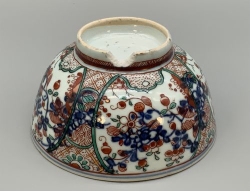 fig 8. An antique deep circular porcelain bowl featuring hand-painted Chinese Imari floral foliage and diaper pattern borders in blue, red, and green.