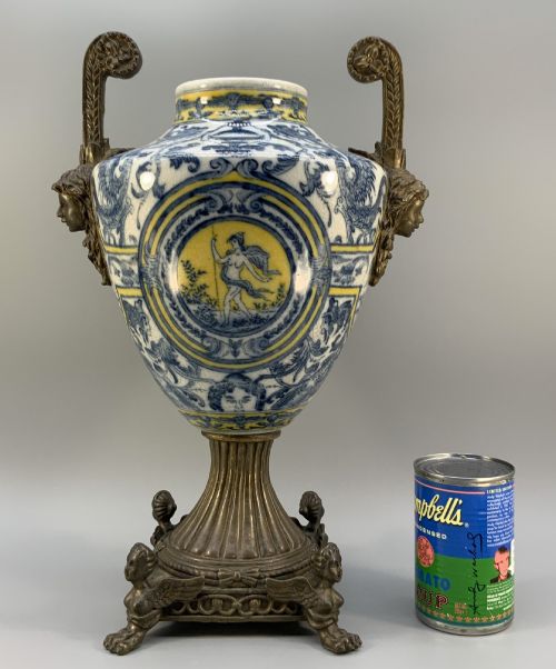 fig 2. A Renaissance Revival faience vase featuring blue and yellow glazed classical medallion artwork mounted on a cast bronze footed base with mask handles.