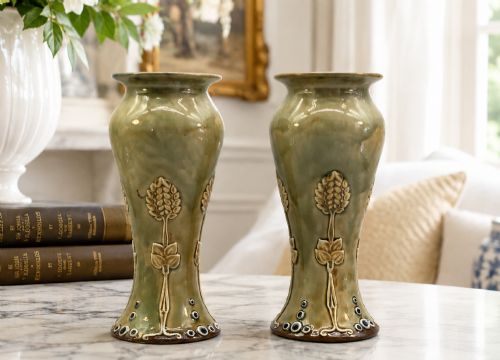 fig 1. A matched pair of Royal Doulton Lambeth Art Nouveau stoneware vases featuring raised relief botanical motifs on a muted olive green glazed ground.