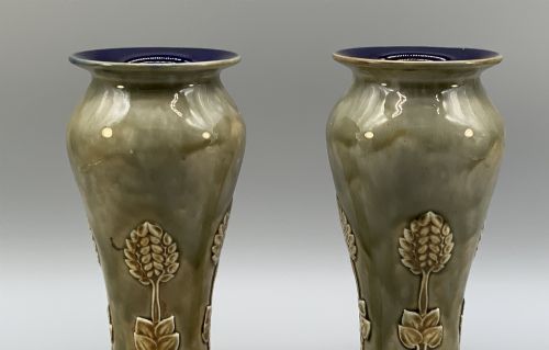 fig 3. A matched pair of Royal Doulton Lambeth Art Nouveau stoneware vases featuring raised relief botanical motifs on a muted olive green glazed ground.