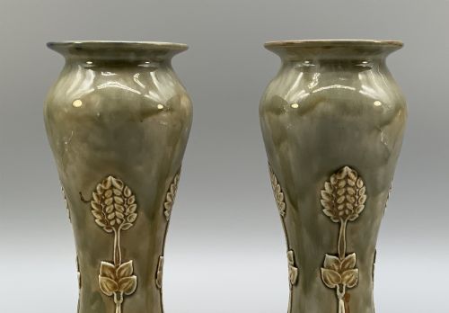 fig 4. A matched pair of Royal Doulton Lambeth Art Nouveau stoneware vases featuring raised relief botanical motifs on a muted olive green glazed ground.