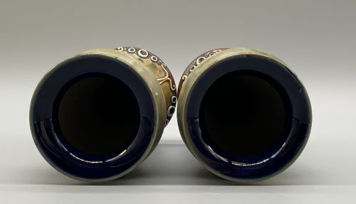 fig 7. A matched pair of Royal Doulton Lambeth Art Nouveau stoneware vases featuring raised relief botanical motifs on a muted olive green glazed ground.
