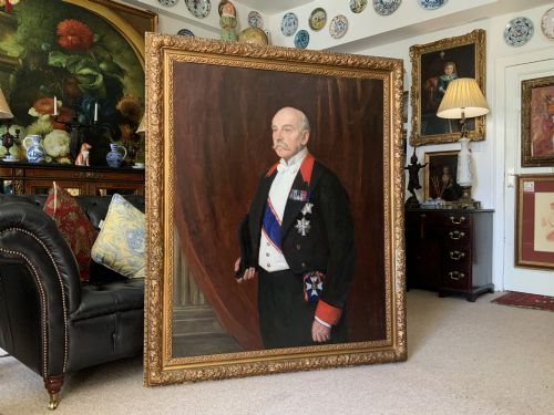 fig 1. An Edwardian portrait painting of a military officer wearing decorations and set within a carved gold frame.
