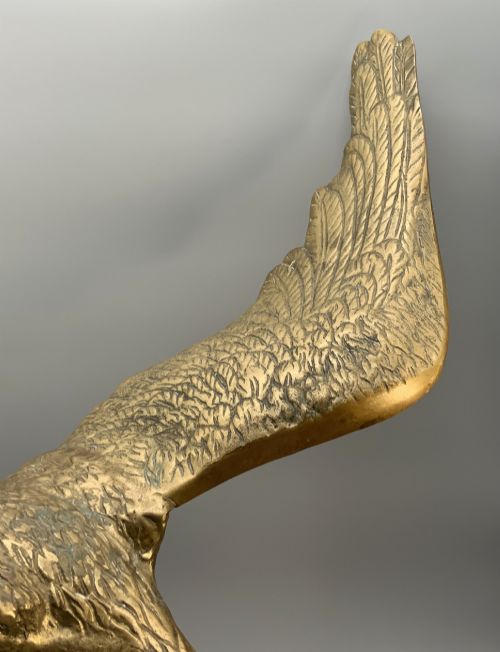 fig 4. A cast brass sculpture depicting an eagle with outstretched wings perched atop a detailed log branch.