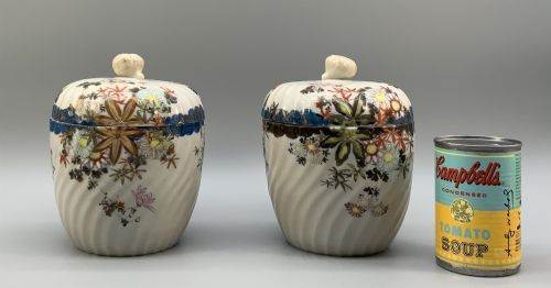fig 2. A pair of 19th-century Japanese cream porcelain lidded jars featuring spiralled fluted bodies and hand-painted polychrome floral decoration with sculpted finials.