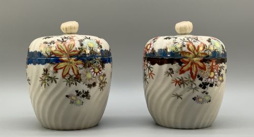 fig 4. A pair of 19th-century Japanese cream porcelain lidded jars featuring spiralled fluted bodies and hand-painted polychrome floral decoration with sculpted finials.