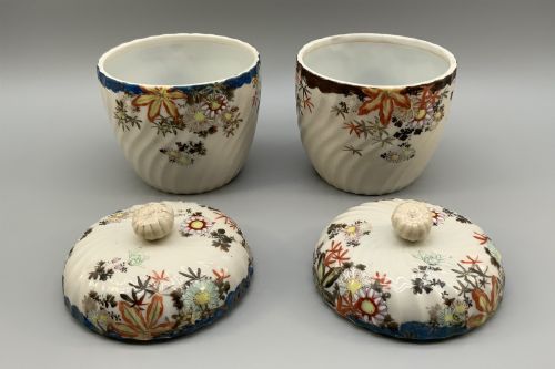 fig 6. A pair of 19th-century Japanese cream porcelain lidded jars featuring spiralled fluted bodies and hand-painted polychrome floral decoration with sculpted finials.
