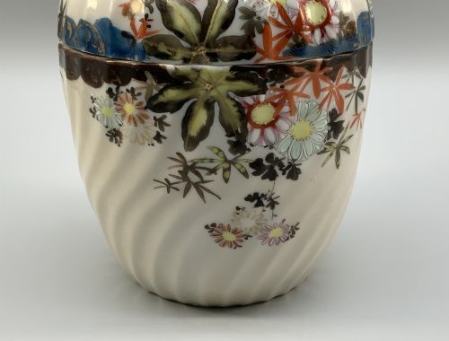 fig 10. A pair of 19th-century Japanese cream porcelain lidded jars featuring spiralled fluted bodies and hand-painted polychrome floral decoration with sculpted finials.