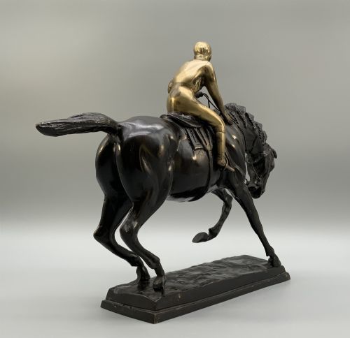 fig 9. A patinated bronze sculpture depicting a racehorse and jockey mid-stride set upon a textured rectangular bronze base.