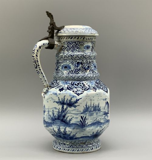 fig 4. An eighteenth-century blue and white Dutch Delftware ceramic jug decorated with hand-painted figures, complete with a fitted pewter lid.