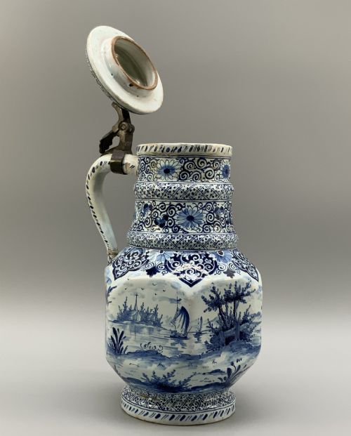 fig 6. An eighteenth-century blue and white Dutch Delftware ceramic jug decorated with hand-painted figures, complete with a fitted pewter lid.