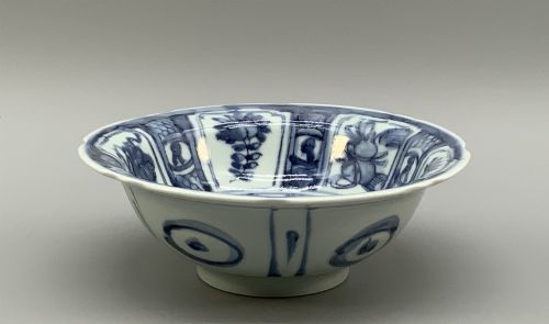 fig 8. A circular porcelain bowl with a lobed edge, decorated in cobalt blue underglaze featuring a central landscape surrounded by panelled floral reserves.