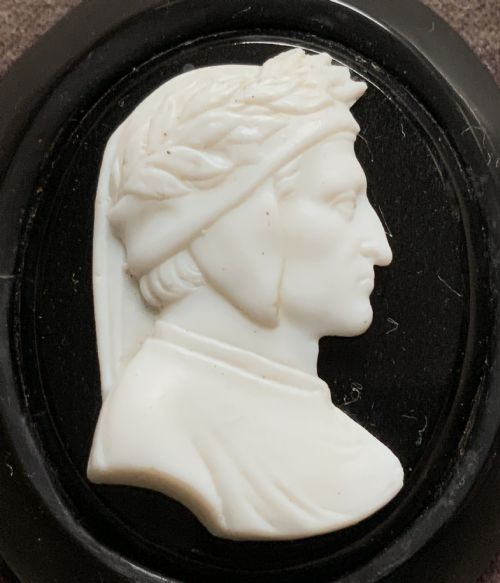 fig 2. A small carved white classical profile portrait cameo mounted on a dark background within a deep black ebonised square frame.