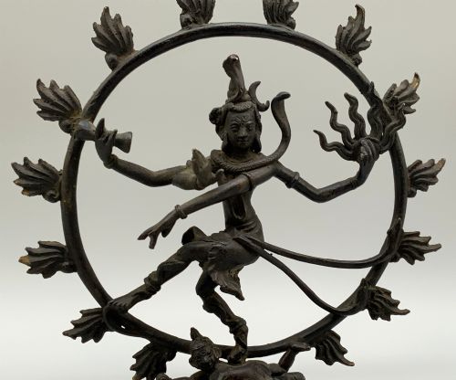 fig 3. A dark patinated bronze 19th-century figure of Shiva Nataraja dancing within a circular halo of flames atop a lotus pedestal.