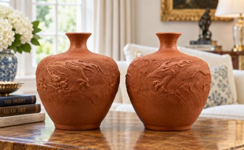 fig 1. A pair of unglazed terracotta red clay vases featuring detailed relief carvings of dragons with narrow flared necks.