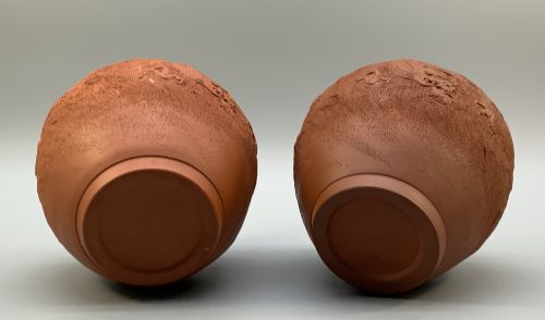 fig 9. A pair of unglazed terracotta red clay vases featuring detailed relief carvings of dragons with narrow flared necks.