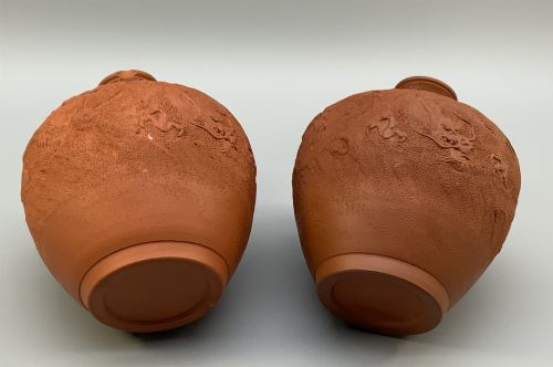 fig 10. A pair of unglazed terracotta red clay vases featuring detailed relief carvings of dragons with narrow flared necks.