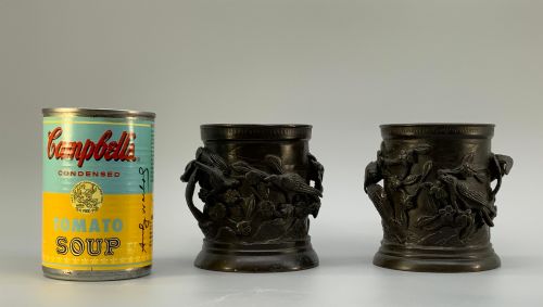 fig 2. A pair of cylindrical dark patinated bronze vases featuring raised relief depictions of birds perched amongst cherry blossom branches.
