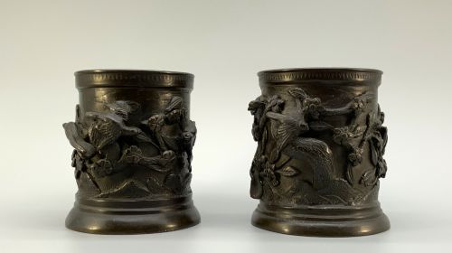 fig 5. A pair of cylindrical dark patinated bronze vases featuring raised relief depictions of birds perched amongst cherry blossom branches.