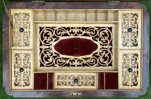 fig 5. A 19th-century burr walnut work table featuring a green leather inset top, floral marquetry inlay, turned legs, and a hanging storage pouch.