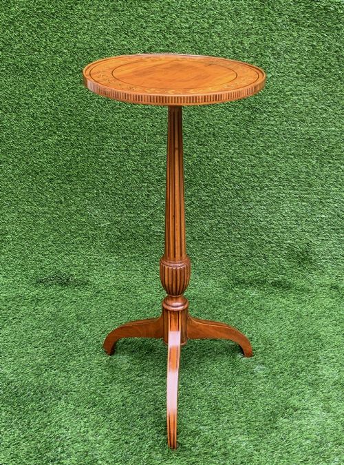 fig 1. A 19th-century satinwood wine table featuring a circular top with inlaid marquetry detailing, supported by a fluted central pedestal and three downswept tripod legs.