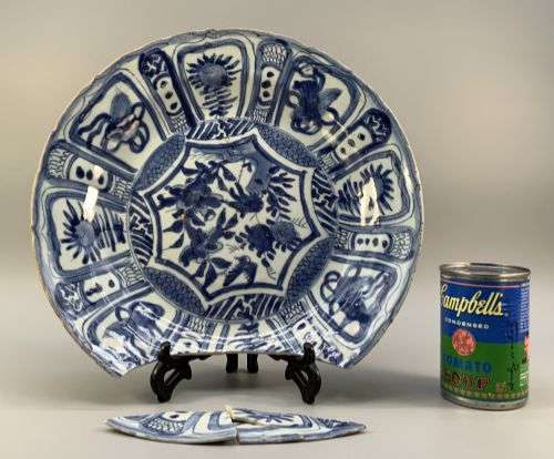 fig 2. A large 17th-century Japanese Edo period blue and white porcelain charger featuring panelled floral patterns with detached rim fragments in the foreground.