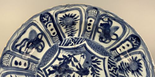 fig 4. A large 17th-century Japanese Edo period blue and white porcelain charger featuring panelled floral patterns with detached rim fragments in the foreground.