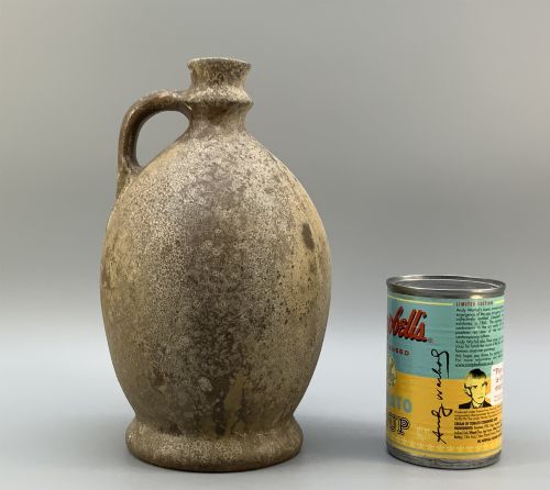 fig 2. A 19th-century salt-glazed stoneware flagon featuring a mottled brown textured surface, narrow neck, flared rim, and a single loop handle.