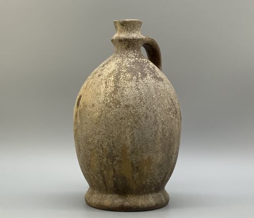 fig 8. A 19th-century salt-glazed stoneware flagon featuring a mottled brown textured surface, narrow neck, flared rim, and a single loop handle.