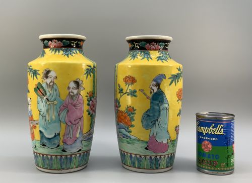fig 2. A pair of yellow ground Chinese porcelain vases decorated with painted figures, floral motifs, and green leaf borders around the base.