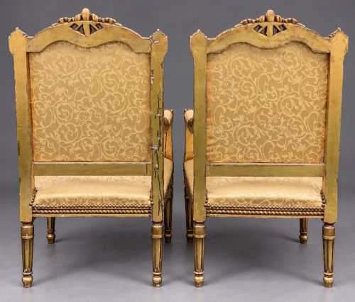 fig 4. A pair of 19th-century giltwood open armchairs featuring carved leaf detailing, button-tufted gold damask upholstery, and fluted front legs.