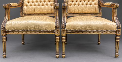 fig 8. A pair of 19th-century giltwood open armchairs featuring carved leaf detailing, button-tufted gold damask upholstery, and fluted front legs.