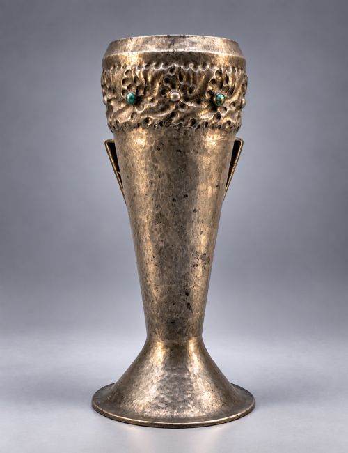 fig 3. An Arts and Crafts hammered pewter vase featuring raised geometric support fins, a textured upper band, and inlaid turquoise cabochons.