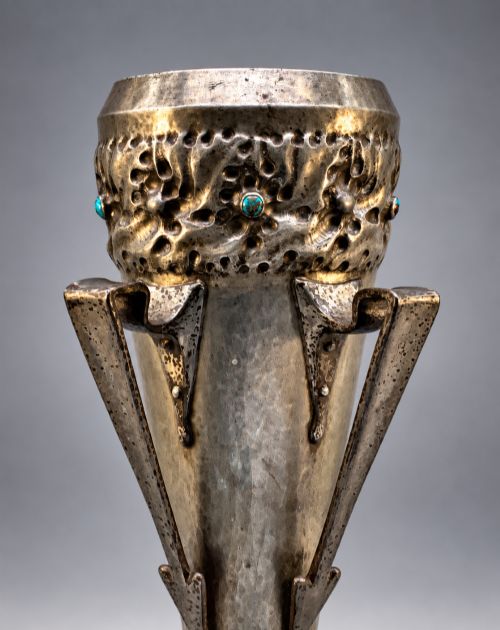fig 4. An Arts and Crafts hammered pewter vase featuring raised geometric support fins, a textured upper band, and inlaid turquoise cabochons.
