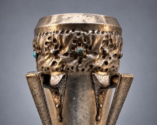 fig 5. An Arts and Crafts hammered pewter vase featuring raised geometric support fins, a textured upper band, and inlaid turquoise cabochons.