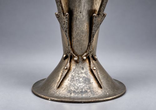 fig 7. An Arts and Crafts hammered pewter vase featuring raised geometric support fins, a textured upper band, and inlaid turquoise cabochons.