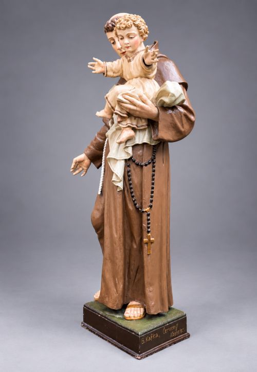 fig 2. An antique polychrome carved wood sculpture depicting Saint Anthony in a brown Franciscan habit holding the Christ Child.